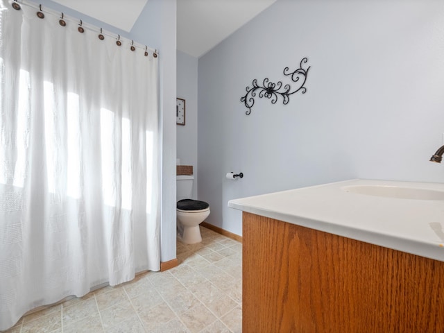 bathroom with baseboards, toilet, and vanity