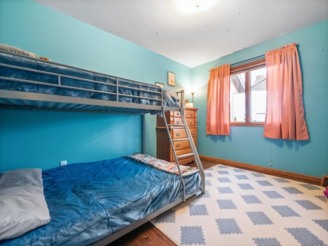 bedroom with a textured ceiling and baseboards