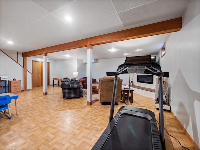 workout room featuring baseboards and a drop ceiling