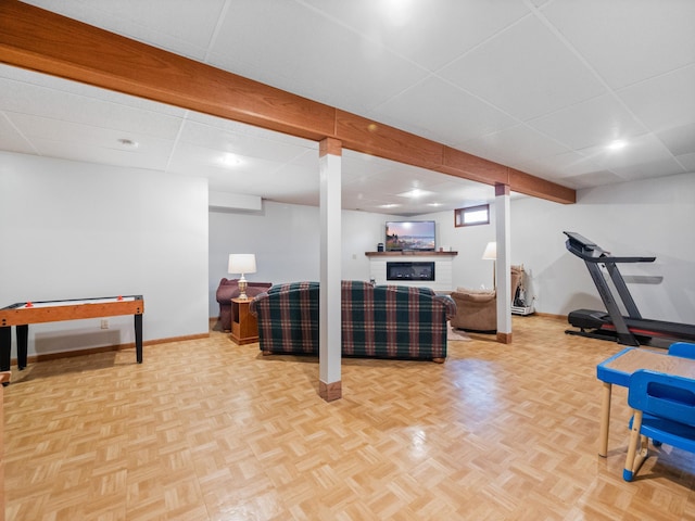 workout area with a drop ceiling, baseboards, and parquet flooring