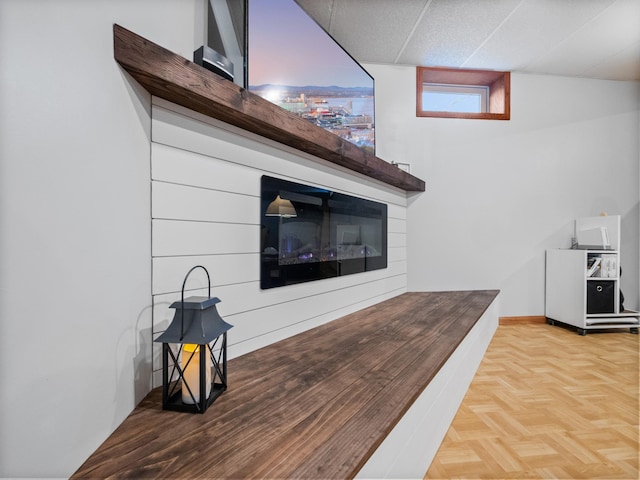 room details featuring a glass covered fireplace and baseboards