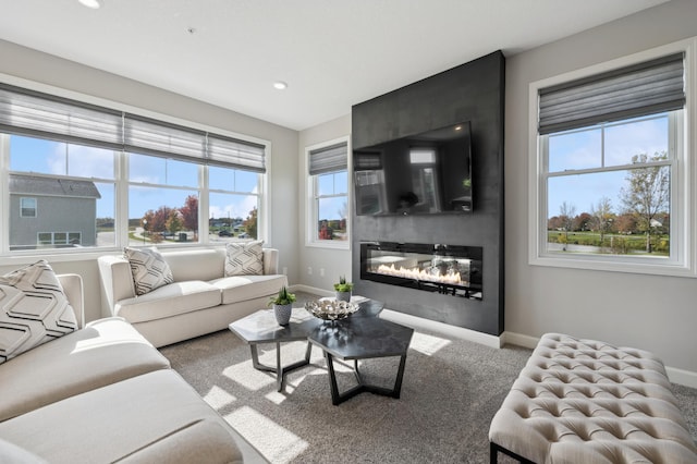 living room featuring plenty of natural light, baseboards, and carpet flooring