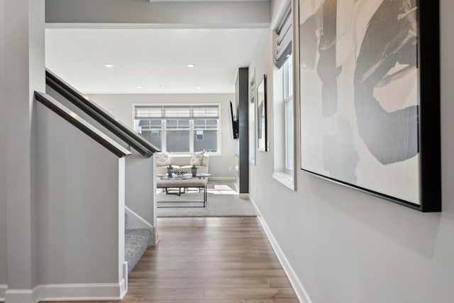 corridor featuring stairs, recessed lighting, baseboards, and wood finished floors