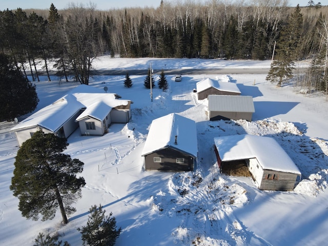 snowy aerial view featuring a forest view