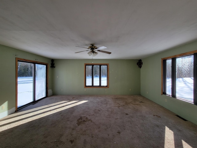 carpeted spare room featuring a ceiling fan