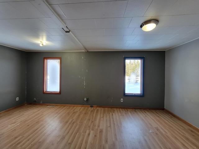 spare room featuring light wood finished floors and baseboards