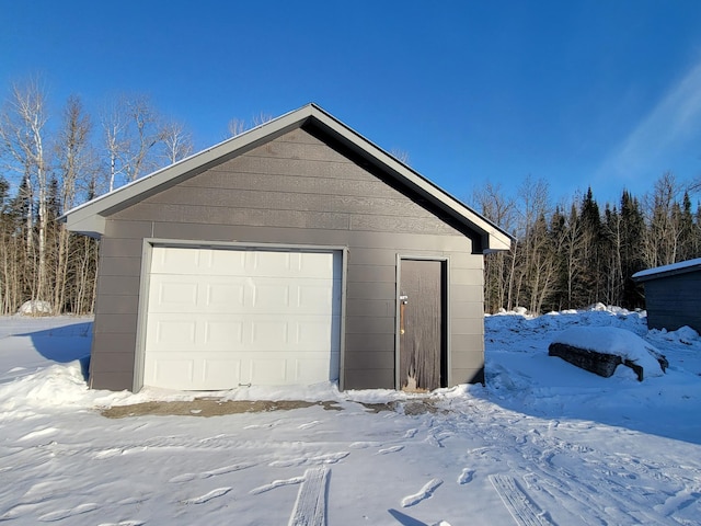 snow covered garage with a garage