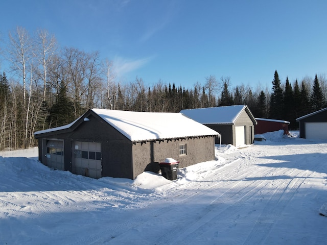 snow covered garage featuring a detached garage