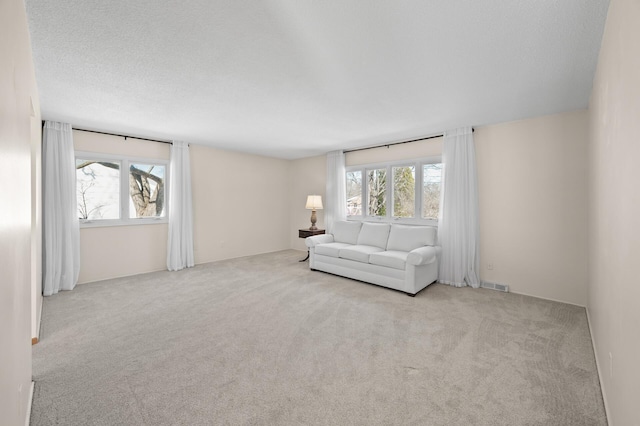 unfurnished living room with carpet floors, visible vents, and a textured ceiling