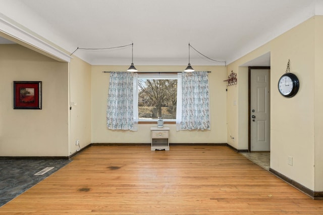 unfurnished dining area with visible vents, wood finished floors, and baseboards