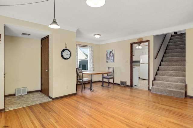 interior space featuring visible vents, baseboards, light wood-style flooring, and stairs