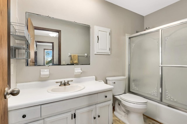 bathroom with toilet, vanity, and shower / bath combination with glass door