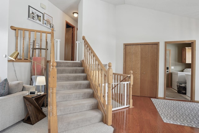 stairs featuring vaulted ceiling, wood finished floors, and separate washer and dryer