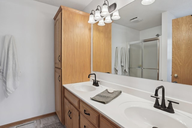 full bathroom featuring a shower stall, double vanity, visible vents, and a sink