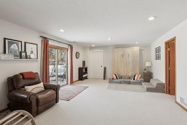 carpeted living area with recessed lighting and a textured ceiling