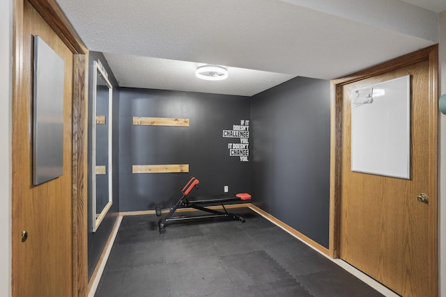 workout room with baseboards and a textured ceiling