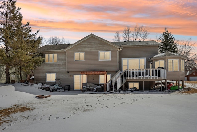 back of property at dusk featuring a fire pit, stairs, and a deck