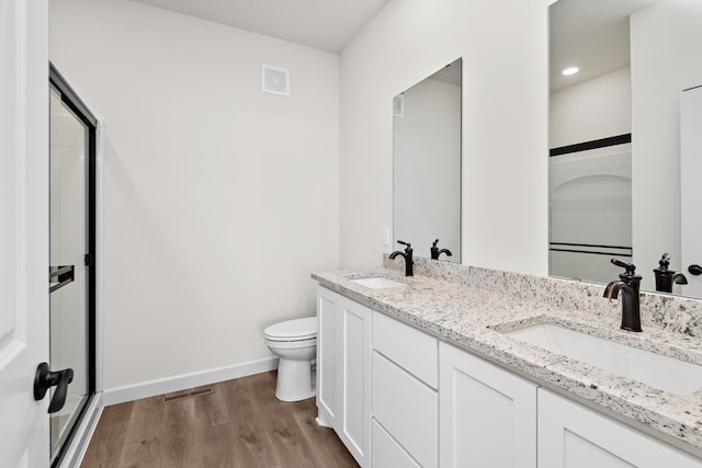 18788 Grant St NW, Elk River, MN 55330 - bathroom with wood finished floors, double vanity, recessed lighting, and a shower with door