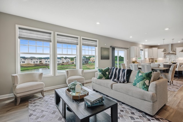 living area with light wood-type flooring, baseboards, and recessed lighting