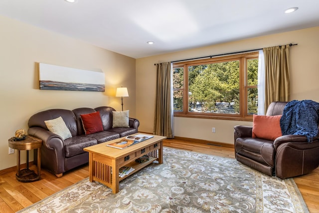 living room with recessed lighting, baseboards, and wood finished floors