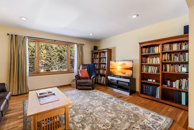 living area featuring baseboards, wood finished floors, and recessed lighting