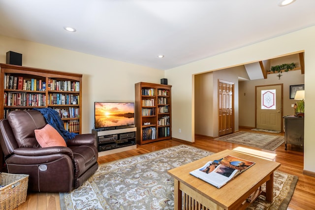 living room with baseboards, wood finished floors, and recessed lighting