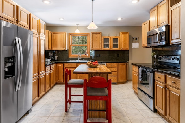 kitchen featuring stainless steel appliances, a center island, a sink, and tasteful backsplash