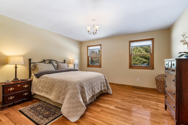 bedroom featuring a notable chandelier and light wood-style flooring