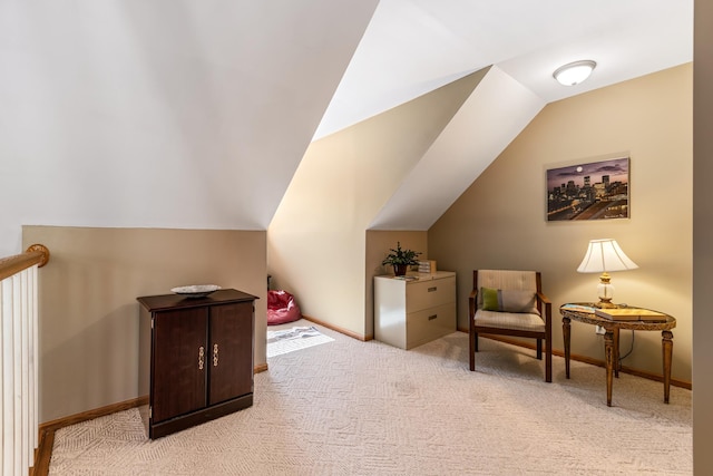 living area with lofted ceiling, light colored carpet, and baseboards