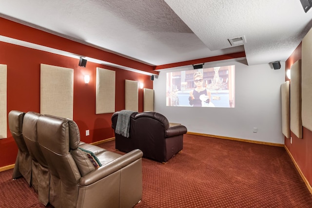 cinema room featuring baseboards, visible vents, a textured ceiling, and carpet flooring