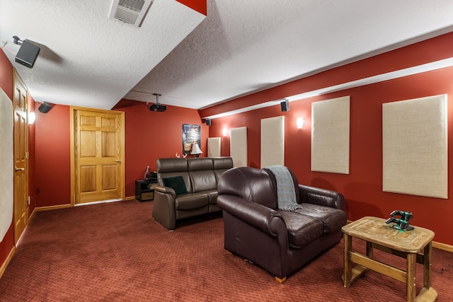 carpeted home theater featuring baseboards, visible vents, and a textured ceiling