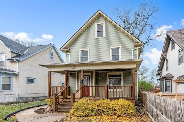 traditional style home featuring a porch and fence