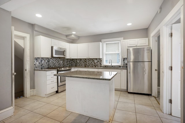 kitchen featuring stainless steel appliances, a sink, backsplash, and light tile patterned floors