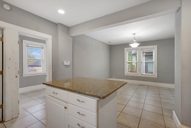 kitchen featuring a healthy amount of sunlight, a kitchen island, and baseboards