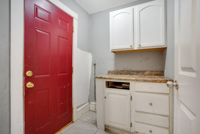 kitchen featuring light tile patterned floors and white cabinetry