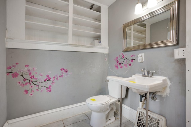 half bathroom featuring toilet, tile patterned flooring, and baseboards