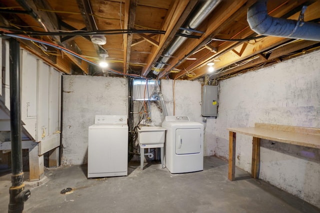 unfinished below grade area with electric panel, a sink, and separate washer and dryer