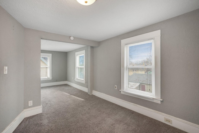 carpeted empty room with baseboards