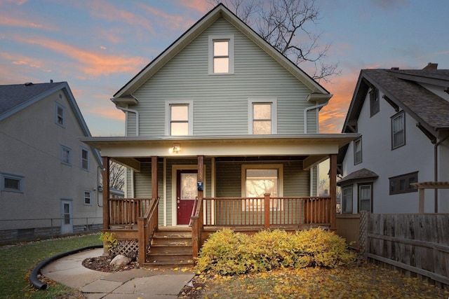 traditional style home with covered porch and fence