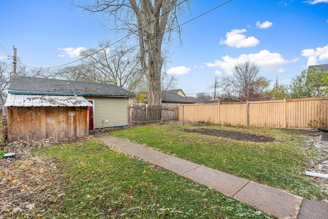 view of yard with an outbuilding, a storage shed, and a fenced backyard