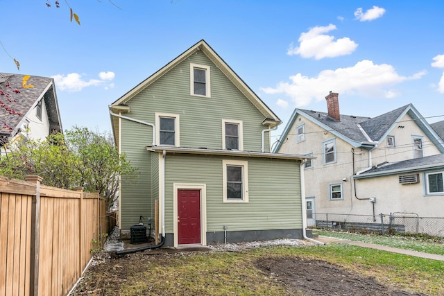 rear view of house with central air condition unit and a fenced backyard