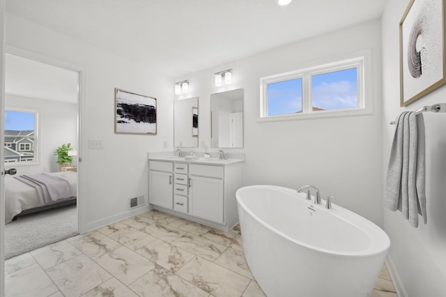 ensuite bathroom with double vanity, marble finish floor, baseboards, and visible vents