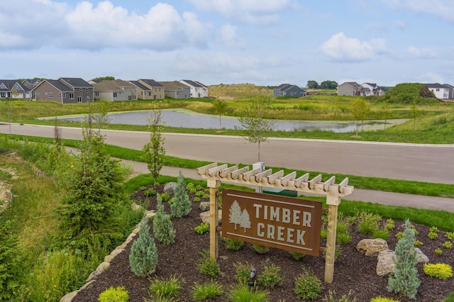 community / neighborhood sign featuring a residential view and a water view