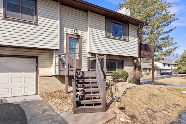 view of front of property with a garage, brick siding, and a chimney