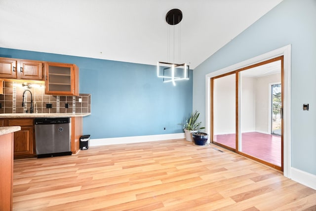 dining room with lofted ceiling, light wood-style floors, and baseboards