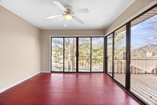 unfurnished sunroom with ceiling fan