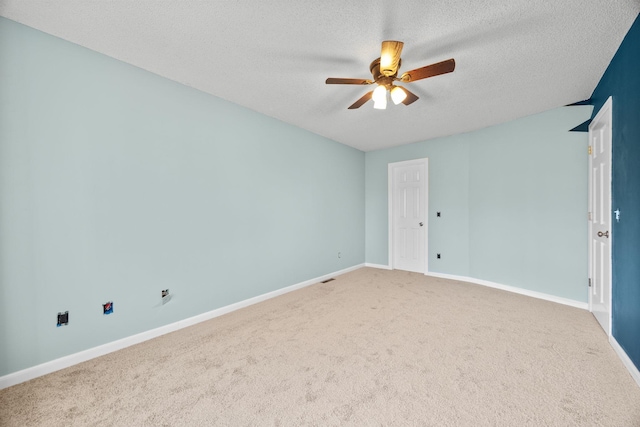 spare room with a ceiling fan, baseboards, carpet floors, and a textured ceiling