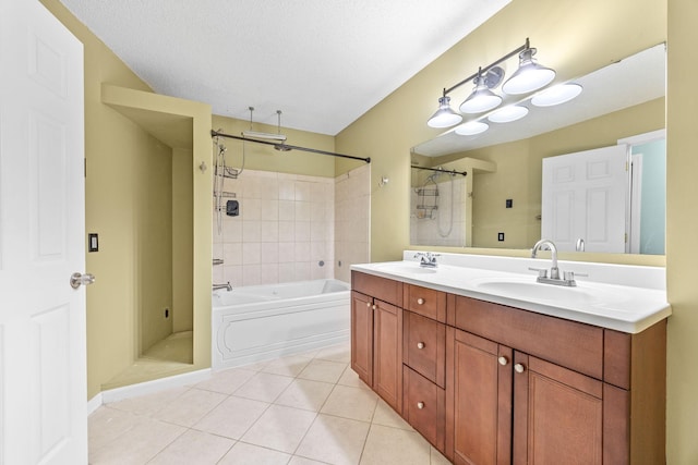 bathroom with a sink, a textured ceiling, double vanity, and tile patterned floors