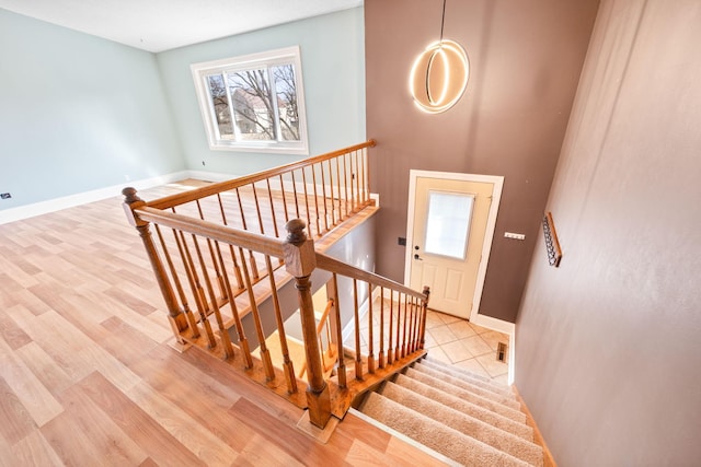 stairs with visible vents, baseboards, and wood finished floors