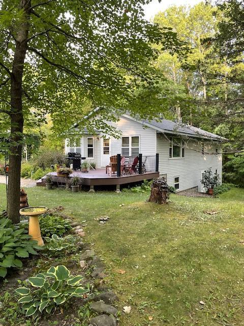 rear view of house with a deck and a yard